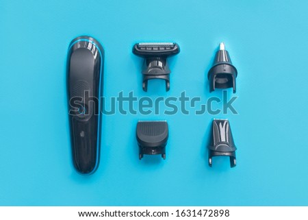 Men still life, flat lay. Composition, set for shaving. Electric razor trimmer with different nozzles for cutting mustache, beard and nose hair. Top view. Kit for male hairstyle. Home barbershop.