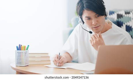 Men taking online lessons on their laptops - Shutterstock ID 2049247136
