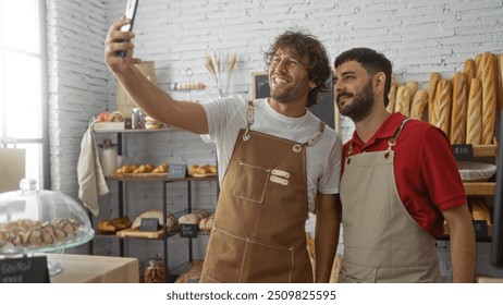 Men taking selfie together in a bakery shop, wearing aprons, surrounded by fresh bread and pastries, depicting friendly bakers in an indoor setting with white brick walls and wooden racks. - Powered by Shutterstock