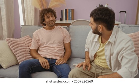 Men talking and smiling together while sitting in a cozy living room, illustrating friendship and family bonds