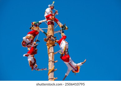 Men tied to pole swing around and around - Powered by Shutterstock