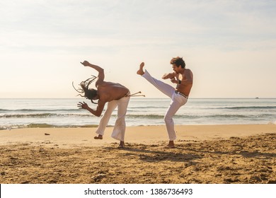 Men train capoeira on the beach - concept about people, lifestyle and sport. Training of two fighter