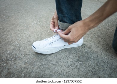 the men are tying sneakers. 