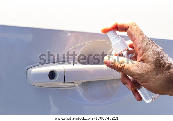 Men use\
alcohol spray to get rid of bacteria and viruses On the car door,\
Inhibition and prevention of Covid-19 virus infection using 70\
percent alcohol, protect virus\
concept.