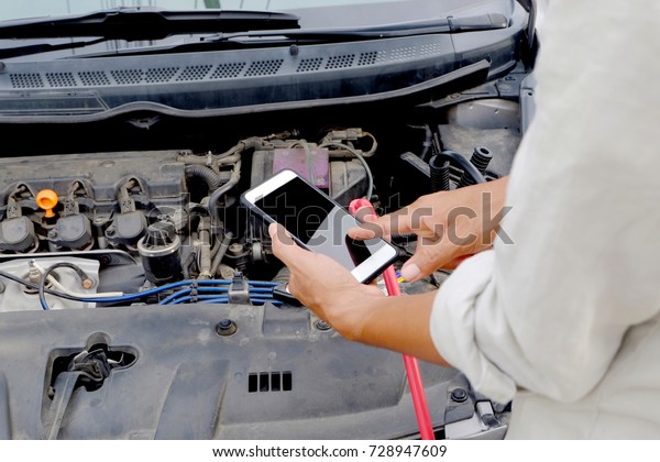 Men use the\
phone to contact the car repair\
shop.