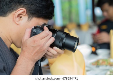 Men are using a camera on the food table