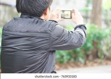 Men are using a mobile phone to take pictures.