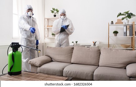 Men in virus protective suit making treatment of sofas and surfaces from coronavirus, preventive measures, copy space