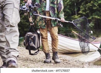 Men walking and carrying fishing tackle 