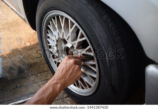 Men\
are washing old tires, dirty cars with bare\
hands.