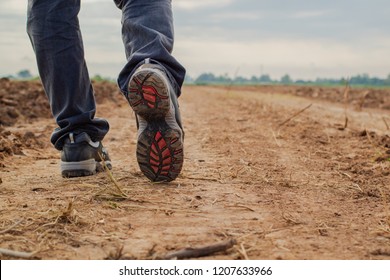Men wear jeans and wear walking shoes on the dirt road.shoes closeup