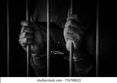 The men were arrested, handcuffed prisoner in jail with dark lighting