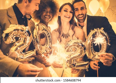 Men and women celebrating the new year 2020 with sparklers and wine