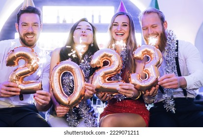 Men and women celebrating the new year 2022 - Shutterstock ID 2229071211