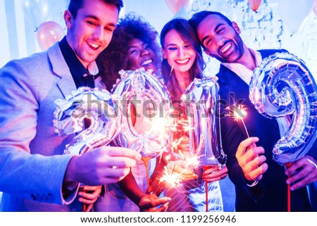 Men and women celebrating the new year 2019 with sparklers and wine