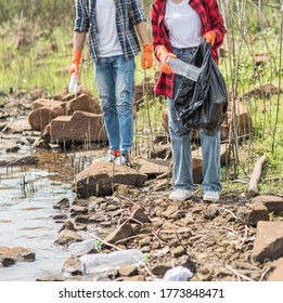 Men and women helped to collect garbage in a black bag. - Shutterstock ID 1773848471