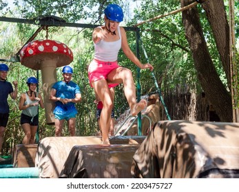 Men And Women Jumping On Floating Platforms To Reach Finish Of Water Obstacle Course. Family Resting 