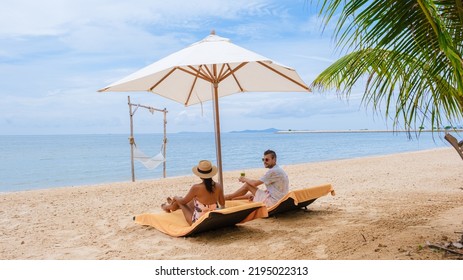 Men and women on the beach are relaxing in a beach chair on a sunny day with a hammock in Pattaya Thailand Ban Amphur beach. couple walking on a tropical beach with palm trees and hammock  - Powered by Shutterstock