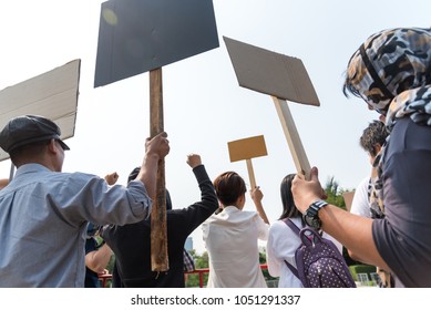 Men and women share a protest sign  hold a megaphone. Mob concept, The youth crowd gathered to protest.