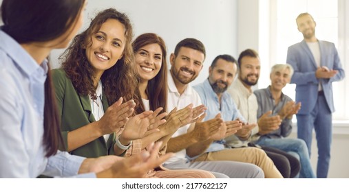 Men and women sit in row on meeting. Group of happy and grateful business people applaud female coach thanking her for interesting lecture at business conference. Cropped image. Selective focus. - Shutterstock ID 2177622127