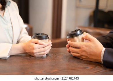 Men And Women Talking Over Coffee At A Cafe