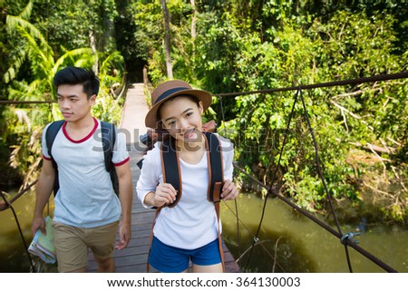 Men and women tourists Were crossing a bridge in the forest or national park.