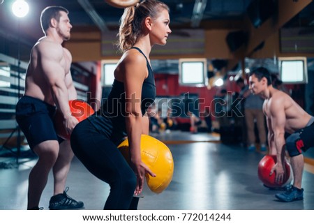 men and women train with the ball in his hands. trainer demonstrates how to perform the exercise.