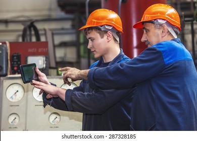 Men Work On The Old Factory For The Installation Of Equipment In Protective Helmets