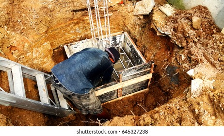 Men are working.The construction of a concrete pole in a temporary wooden frame
