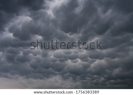 Menacing mammatus clouds before the storm, stormy sky, climate change and unpredictable terrifying mother nature