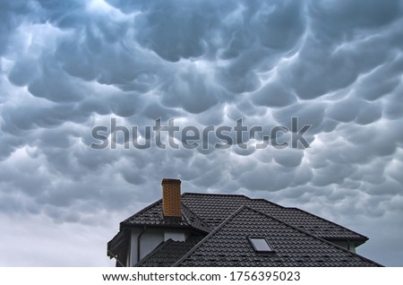 Menacing mammatus clouds before the storm, stormy sky, climate change and unpredictable terrifying mother nature