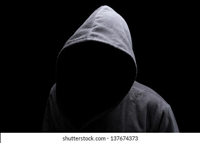 Menacing silhouette of hooded man in the shadow