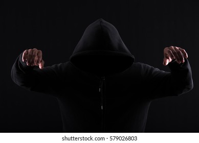 Menacing silhouette of hooded man in the shadow - Powered by Shutterstock