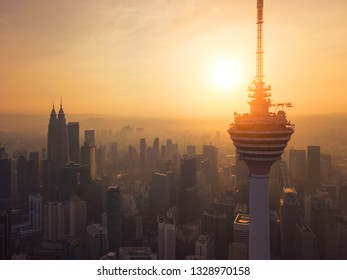 Menara Kuala Lumpur Tower With The Sun. Aerial View Of Kuala Lumpur Downtown, Malaysia. Financial District And Business Centers In Urban City In Asia. Skyscraper And High-rise Buildings At Sunset.