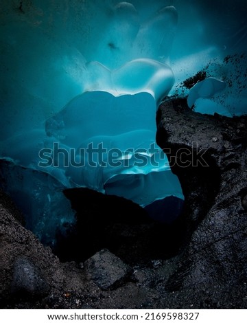 Mendenhall Glacier vibrant blue ice cave in Juneau, Alaska on a summer day.