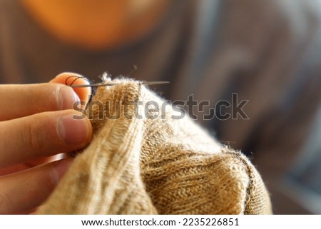 Mending clothes. Concept of mending and repairing clothes. Creative sustainable fashion and recycling. Selective focus