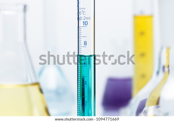 Meniscus. Curved surface (meniscus) of green solution\
in a graduated cylinder.  The volume of liquid is measured by\
reading the scale at the bottom of the meniscus. Here the reading\
is 6.9 mL.
