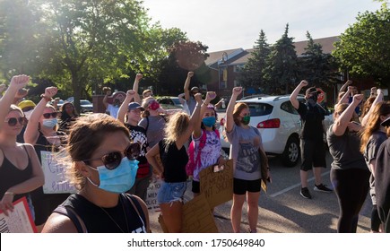 Menomonee Falls, Wisconsin - 06/06/20: Hundreds of Peaceful Protesters Hold Their Fists in the air for the Black Lives Matter Movement