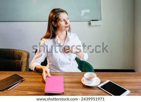 A menopausal business woman n boardroom alone. Gradual process. Beautiful mature woman touching shirt and having hot flash. Foto stock © 