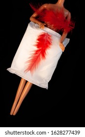 Menorrhagia Heavy Menstruation Bleeding Concept.Irregular Period. Doll Body With Menstrual Pad And Red Feather On Black Background.Feminine Critical Days Hygiene Product.Creative Minimalism Dark Photo