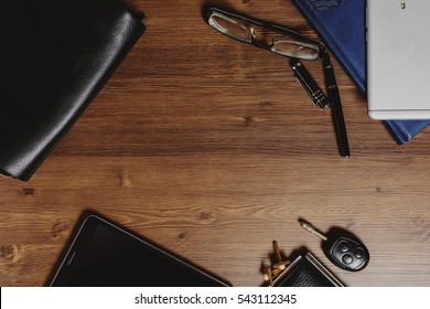 Men's Accessories (bag, Eau De Toilette, Perfumes, Car Keys, Cufflinks And Wallets With Dollars) And A Mobile Phone On A Wooden Table