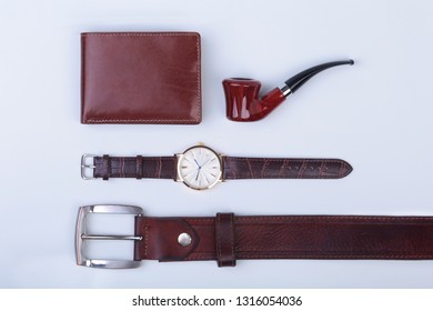 Men's accessories for business and rekreation. Leather belt, wallet, watch and smoking pipe on white background.. Top view composition. - Powered by Shutterstock