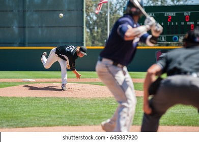 Mens' baseball pitcher throwing the curveball to the batter. 