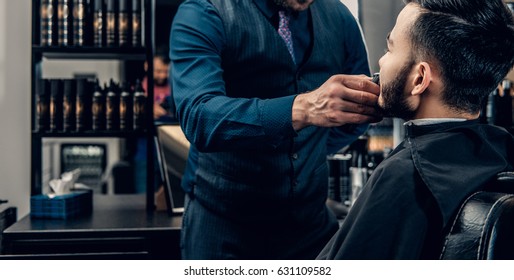 Men's Beard Grooming With The Electronic Beard Trimmer In A Barbershop.