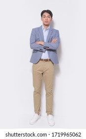 Men's Beauty, Fashion. Handsome Full Body Young Man In Blue Suit With Khaki Pants , , Arms Folded Posing At Studio


