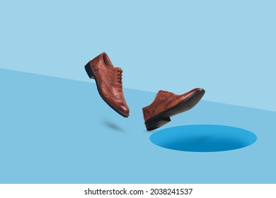 Men's  brown leather shoes in motion falling into dark hole in a floor. Businessman walking into a trap hole. Minimal concept of danger.