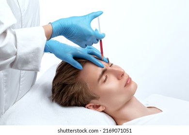 Men's cosmetology. Beautician makes a man a rejuvenation injection procedure on his face. - Shutterstock ID 2169071051