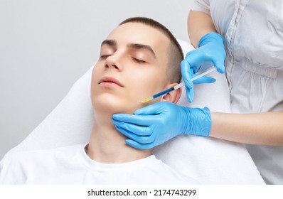 Men's cosmetology. Beautician makes a man a rejuvenation injection procedure of a handsome young man in a beauty salon. - Shutterstock ID 2174743299