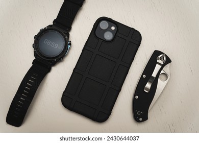 Men's edc items, smart watch, smartphone and folding knife. High quality photo
