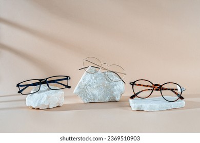 Men's eyewear collection. Glasses sale banner. Optic store sale-out offer. Trendy glasses in plastic and metallic frame on stones on a beige background. Copy space. Optic store discount. Minimalism - Powered by Shutterstock